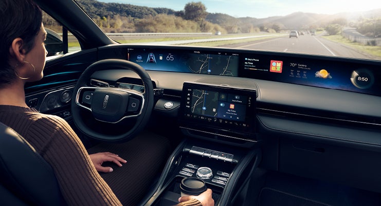 A driver of a Lincoln Nautilus® SUV is shown with the Lincoln Panoramic Display.